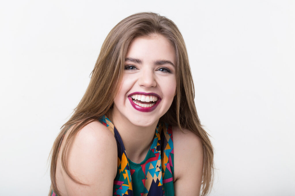 Beauty Portrait Of Attractive Woman With A Natural Open Smile, Hairstyle And Glamour Makeup.